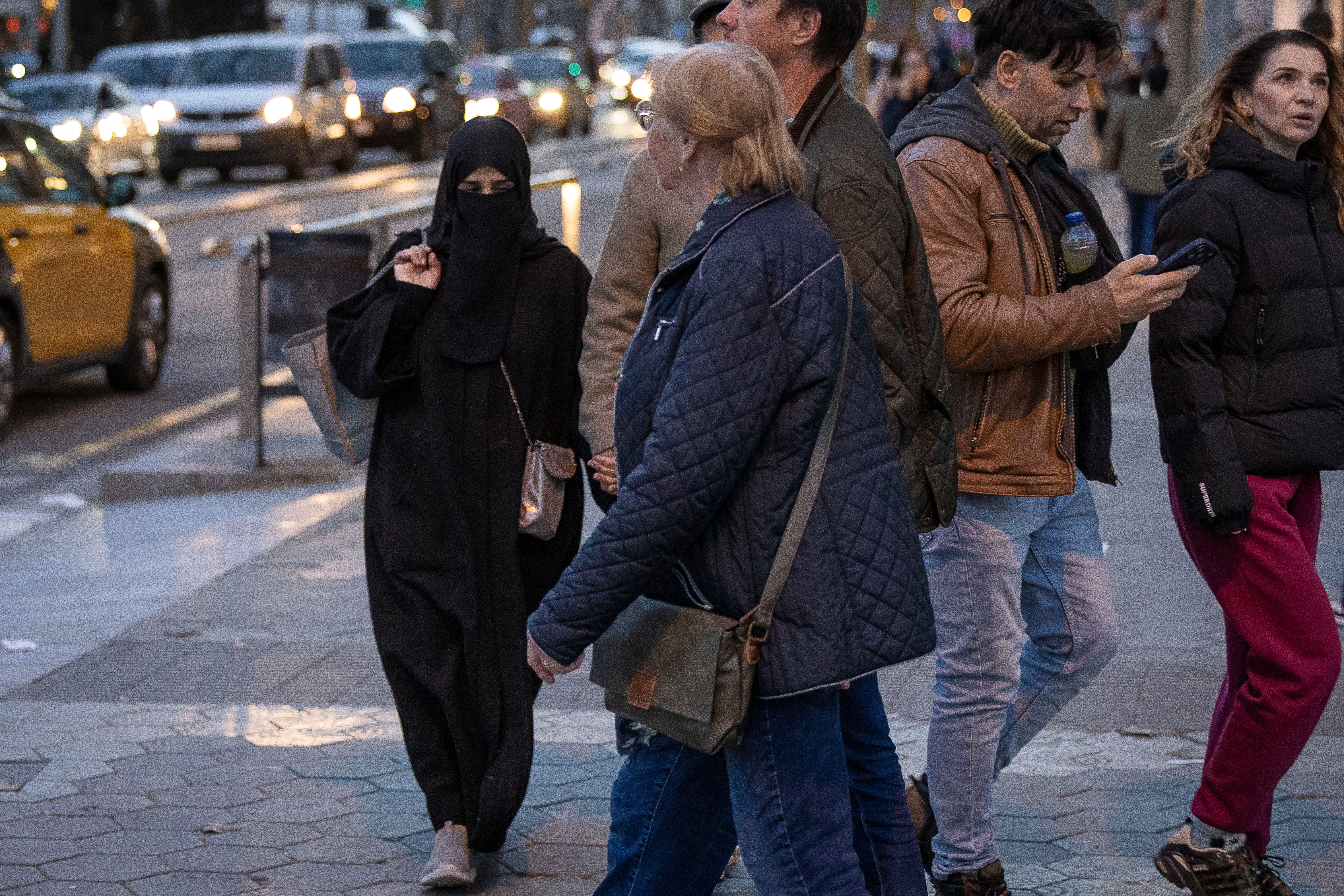 Una mujer ataviada con un velo 'niqab', camina por el paseo de Gràcia de Barcelona.