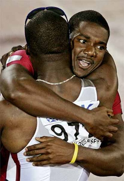 Justin Gatlin se abraza a un corredor de su país tras ganar los 200 metros lisos.