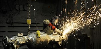 Un trabajador pule uno de los ejes para Caterpillar fabricados de una pieza en acero carbono en las instalaciones de Novacero en Vitoria.