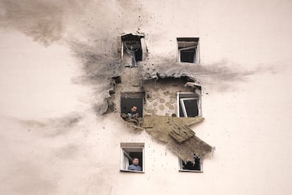 Varias personas observan los daños de un edificio de apartamentos atacado por dron ucraniano en Sapronovo, a las afueras de Moscú.