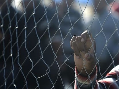 Un hombre se apoya en una valla mientras espera obtener el permiso para ir hacia Macedonia, el 21 de septiembre de 2015.