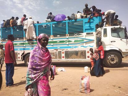 People board a truck as they leave Khartoum, Sudan