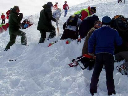 Miembros del cuerpo de rescate buscan víctimas en el sitio en el que se ha producido la avalancha.