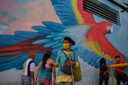 Una mujer camina por el vecindario de Petare después de que el Gobierno aliviara el bloqueo nacional impuesto como medida preventiva contra el coronavirus, en Caracas (Venezuela). Venezuela ha iniciado este lunes una flexibilización de la cuarentena impuesta para frenar la expansión de la pandemia del coronavirus bajo tres niveles y con el método 7+7, un sistema que alterna restricciones durante siete días con un alivio de las mismas durante el mismo período.