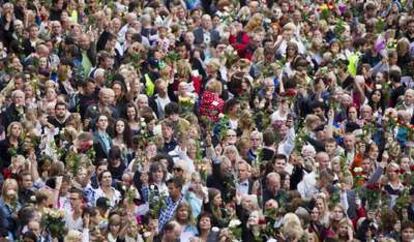 Miles de personas se reúnen en el ayuntamiento de Oslo, Noruega, en homenaje a las 76 víctimas del doble atentado del pasado viernes