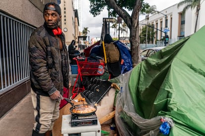 Una persona sin hogar, a las afueras de una biblioteca, en marzo de 2023