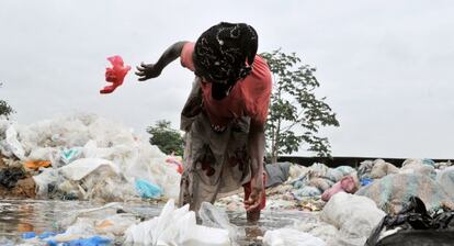 Una mujer recoge bolsas para reciclarlas en Yopougon, en Costa de Marfil.