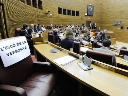 El grupo de Esquerra Unida en las Cortes Valencianas cuelga el cartel &quot;el esca&ntilde;o de la verg&uuml;enza&quot; en la butaca del diputado condenado, Rafael Blasco.