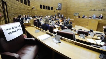 El grupo de Esquerra Unida en las Cortes Valencianas cuelga el cartel "el escaño de la vergüenza" en la butaca del diputado condenado, Rafael Blasco.