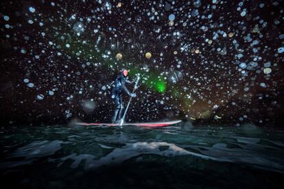 Myrtille Heissat hace padel surf bajo una aurora boreal en Unstad, en las Islas Lofoten (Noruega).