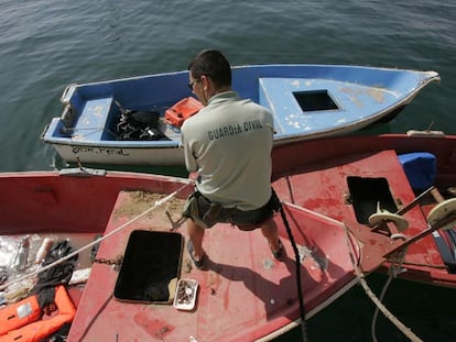 Un guardia civil inspeccionaba ayer la nueva patera llegada a la zona del Cabo de Huertas, en Alicante.