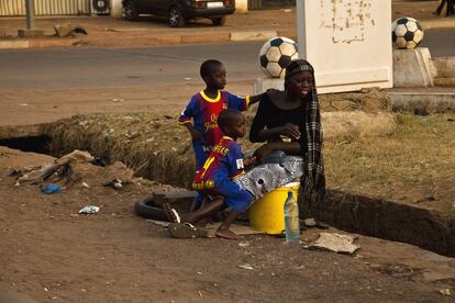 Una madre reposa con sus hijos en el barrio del Hippodrome, Bamako, donde el fútbol es una de las grandes pasiones de los menores.