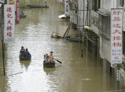 Los residentes de un barrio afectado por las inundaciones recorren las calles en barca