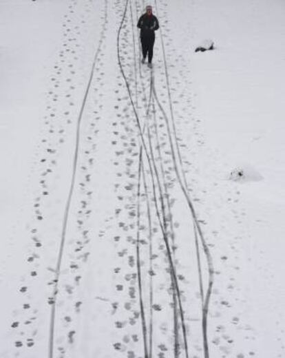 Un hombre practica deporte en una calle cubierta de nieve en Fráncfort (Alemania).