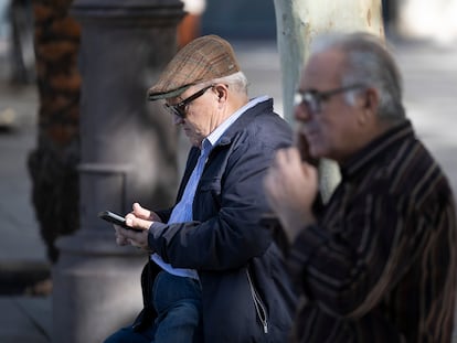 Un hombre mayor usa su teléfono móvil este miércoles en Sevilla.