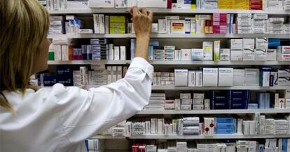 Una farmacéutica ante estantes de medicamentos.