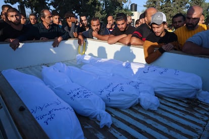 Un grupo de palestinos mostraba su tristeza junto a los cadáveres de familiares y amigos muertos durante los bombardeos israelíes en Rafah, antes de su funeral este martes. 