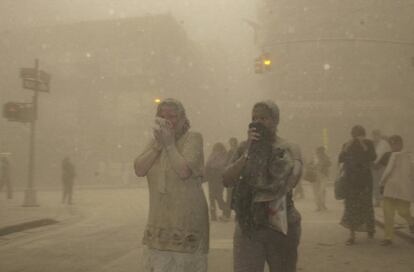 Varios ciudadanos aparecen cubiertos de polvo mientras huyen de la zona tras el desplome de las Torres Gemelas.