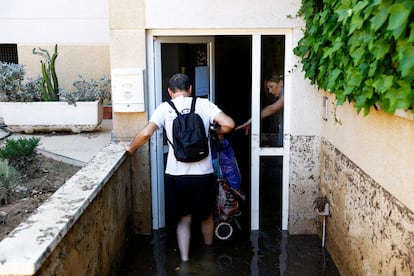 Unos vecinos de Cubelles entran en un edificio inundado por las lluvias del sábado.