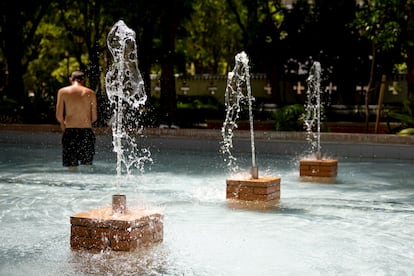 Un hombre se refresca en una fuente este lunes en Sevilla.

