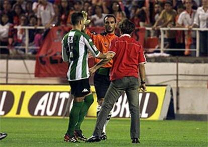 Ito sujeta al hincha tras agredir a Prats, que hace un gesto también con la mano para pararlo.