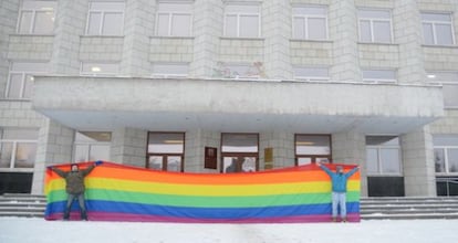 Los activistas Nikolai Alekseyev y Alexey Kiselev sostienen una bandera gay en una protesta.