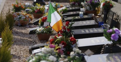 Una bandera nacional irlandesa sobre una tumba de la zona republicana del cementerio Milltown, en Belfast.