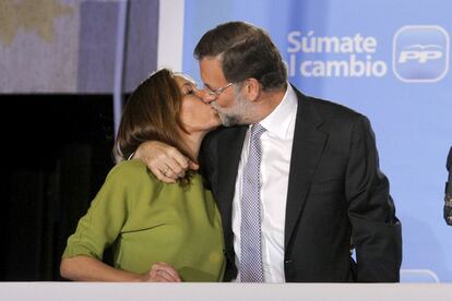 El candidato del Partido Popular a la presidencia del Gobierno, Mariano Rajoy, besa a su mujer, Elvira Fernández, en presencia de los miles de militantes y simpatizantes que se han concentrado para festejar el triunfo de los populares en la sede de la calle Génova.