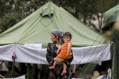Una refugiada de etnia uzbeka mantiene a su hija en brazos en un campo de acogida en Uzbekistán tras haber huido de Kirguizistán.