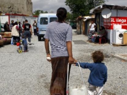 Una mujer acarrea un botellón de agua con su hijo en la Cañada Real.