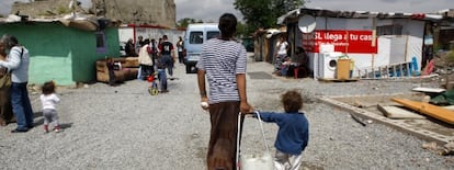 Una mujer acarrea un botellón de agua con su hijo en la Cañada Real.