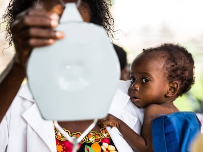 Un bebé mira la báscula antes de ser pesado en una sesión de chequeo médico en República Democrática del Congo. 