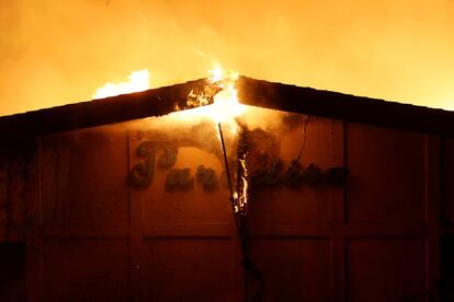 Impulsado por fuertes vientos y condiciones secas, 'Camp Fire' ha arrasado la ciudad de Paradise y ha amenazado a sus 26.000 residentes con llamas de hasta 15 metros de altura. En la imagen, letrero en llamas en un edificio en Paradise, en el Estado de California.