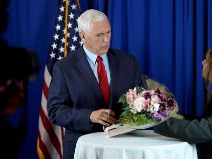 Former Vice President Mike Pence, left, is presented with flowers by Dhara Patel, of Keene, N.H., right, while signing copies of his book "So Help Me God," before the start of a GOP fundraising dinner, Thursday, March 16, 2023, in Keene, N.H.