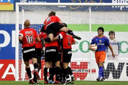 Los jugadores del Mallorca festejan su primer gol, mientras Ayala saca el balón de la portería.