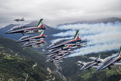 Un avión Breitling DC-3 (arriba) vuela escoltado por un equipo de exhibición acróbata de las Fuerzas Aéreas de Italia, Frecce Tricolori, en la última etapa de su tour mundial de dos días de cara a la celebración de la Feria Internacional de Aviación de Sion, en Suiza.