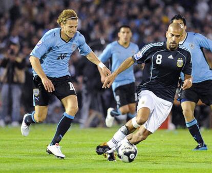 Forlán persigue a Verón, durante un partido de clasificación para el Mundial de 2010.