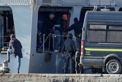Un migrante desciende, esposado, de la nave militar italiana que ha llevado 40 extranjeros al puerto de Shëngjin, Albania, para ser recluidos en el centro de internamiento de Gjadër.