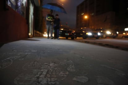 Detalle de huellas en las aceras que los peatones dejan a su paso tras la caída de ceniza en la ciudad de San José (Costa Rica).