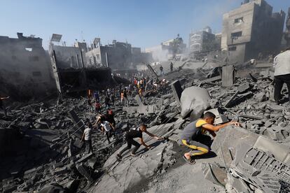Un grupo de palestinos buscan supervivientes entre los escombros de un edificio bombardeado por Israel en Jan Yunis. 