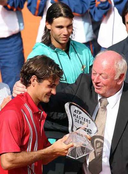 Federer recibe el trofeo de ganador del director del torneo, Walter Knapper, ante la mirada de Nadal.
