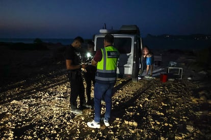 San José'den bir çift yerel polis memuru ve Consell'den (Consell) bir Ulaştırma Müfettişi, Torre D'en Rovira'da bir karavan için izinleri kontrol ediyor.