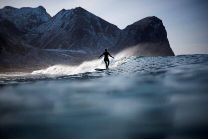 Nesta época do ano nas Ilhas Lofoten a água está a 4º e o ar a -15º. Na imagem, um surfista em Unstad, nas Ilhas Lofoten (Noruega).