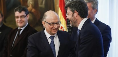 El ministro de Hacienda, Cristóbal Montoro, saluda al secretario de Estado de Presupuestos, Alberto Nadal, ante la mirada del ministro de Energía, Álvaro Nadal.