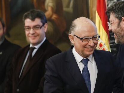 El ministro de Hacienda, Cristóbal Montoro, saluda al secretario de Estado de Presupuestos, Alberto Nadal, ante la mirada del ministro de Energía, Álvaro Nadal.