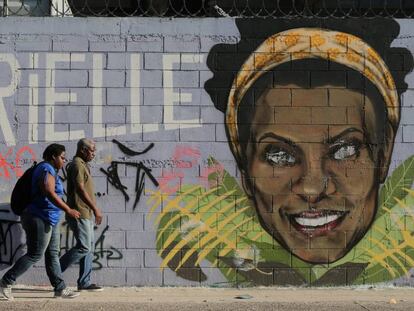 Dois transeúntes ante um grafiti de Marielle Franco, o vereador assassinada faz em um ano em Rio.