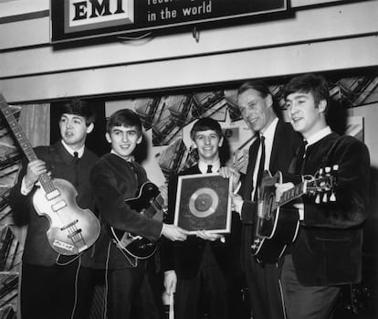 The Beatles, buque insignia de EMI. En la imagen, el cuarteto recoge un disco de plata de manos de George Martin. 