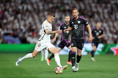 Toni Kroos del Real Madrid, conduce  el balón ante la presencia de  Harry Kane, del Bayern.