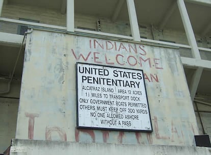 Cartel de bienvenida a los visitantes de la isla. Encima de él aún se conservan parte de las pintadas que dejaron el grupo de nativos norteamericanos que ocuparon la prisión en 1969