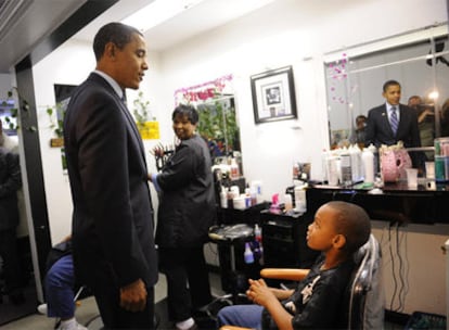 Barack Obama saluda a una clienta de una peluquería en Roanoke, en Virginia.